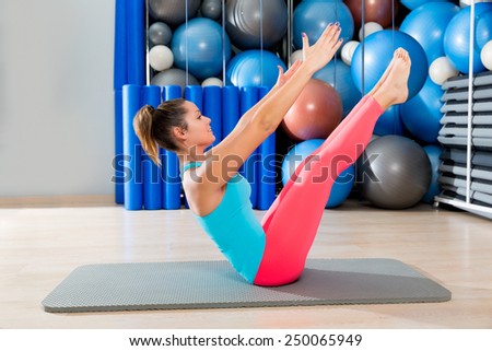 Pilates Teaser exercise woman on mat gym indoor and swiss balls background