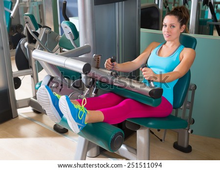 Gym seated leg curl machine exercise woman at indoor