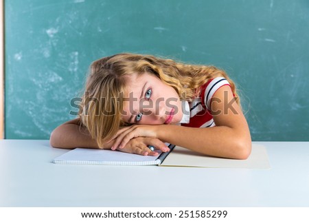 Boring sad expression student schoolgirl on classroom desk at school green chalk board