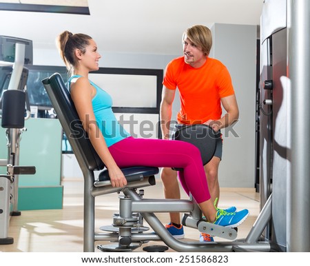 Hip abduction woman exercise at gym indoor closing legs and personal trainer blond man