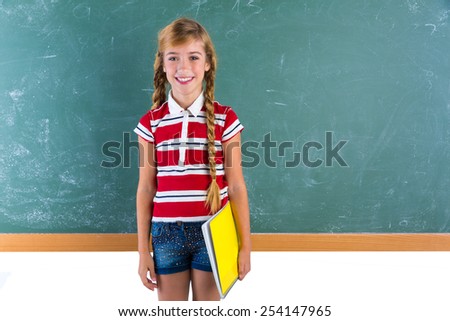 Blond braids schoolgirl with student spiral notebook at class green chalk board
