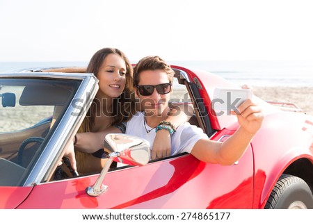 selfie photo of young teen couple in convertible sports car