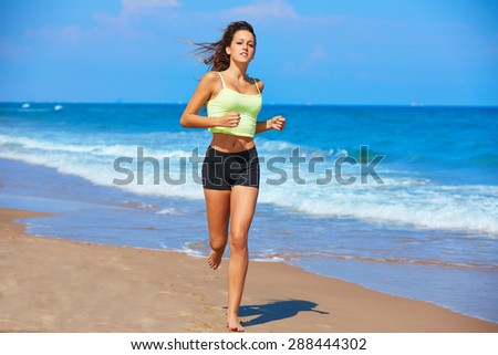 Beautiful brunette girl running in the beach at summer vacations