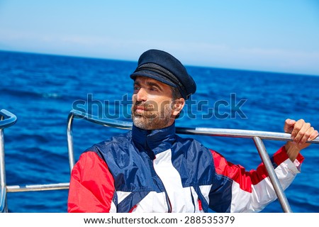 Beard sailor man sailing sea ocean in a boat with captain cap looking horizon