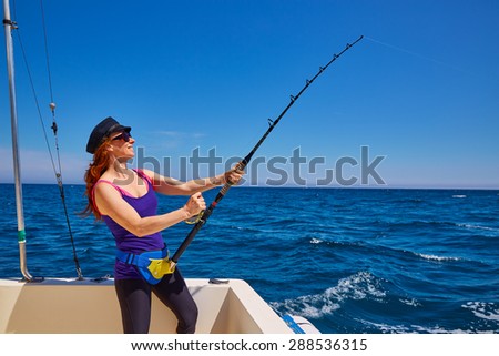 Beautiful woman girl fishing rod trolling in saltwater in a boat trolling