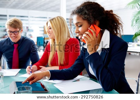 African businesswoman talking phone and touch pad in teamwork meeting at office
