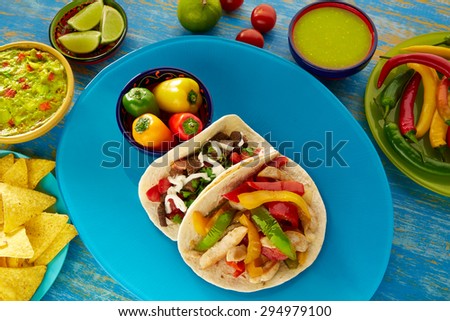 Mexican tacos chicken fajita and beef res taco with guacamole nacho and chili pepper sauce