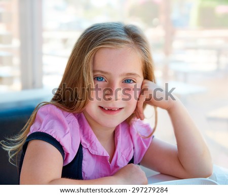 Blond relaxed happy kid girl expression blue eyes smiling