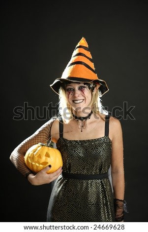 Witch woman dress for halloween with orange hat and pumpkin. Dark make-up