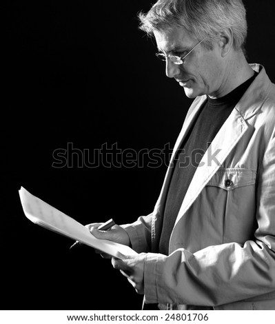 businessman reading at work, senior gray hair, isolated on black