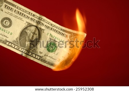 Dollar note, american currency burning in fire over red background, studio shot