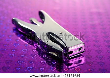professional office stuff, chrome stapler over purple heart background