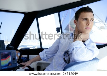 Young handsome man on a yacht boat interior in summer