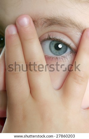 Little shy girl hide her face with fingers, blue eye