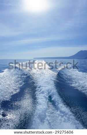 Fishing speedy boat prop wash, white wake on the blue ocean sea
