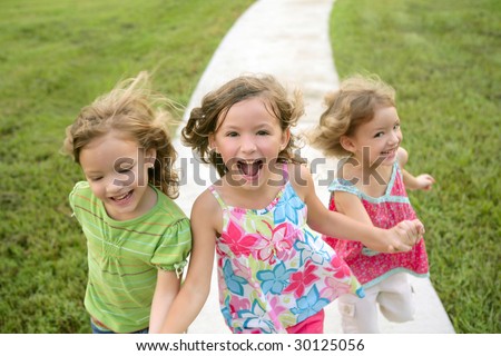 stock photo Three sister girls playing running on the green park outdoor