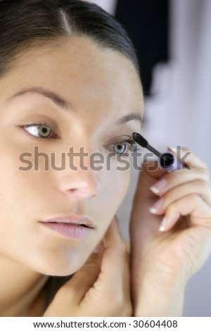 Beautiful woman portrait on the mirror with eye self makeup