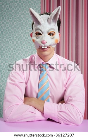 Businessman with funny rabbit easter mask portrait over wallpaper