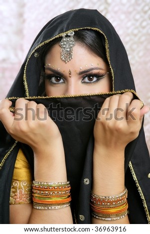 Beautiful brunette asian girl with black veil on face, traditional indian costume