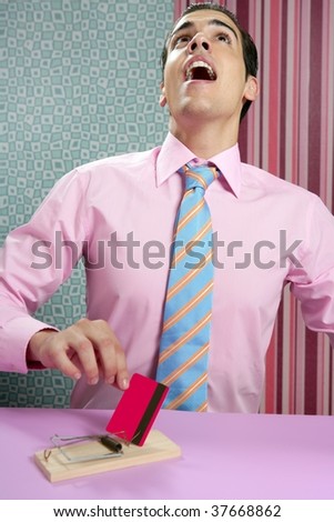 Young businessman hold credit card from mouse trap on wallpaper background