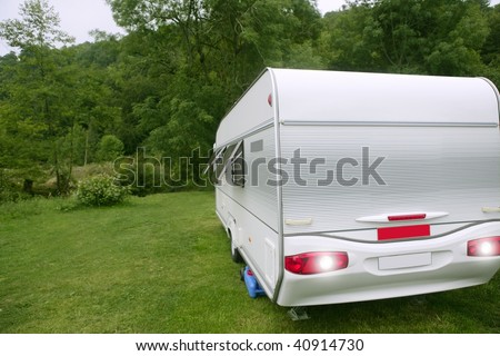 Caravan van in the green meadow forest camping