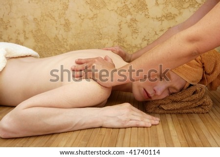 Beautiful woman receiving a back massage over bamboo spa