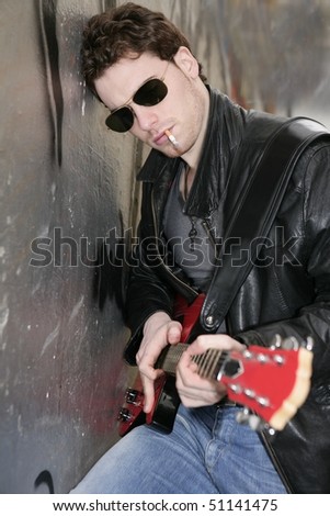 smoking cigarette rock leather boy playing guitar outdoor on silver wall background