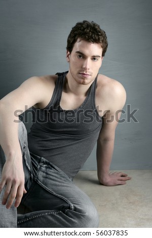 casual young man portrait sit over gray grunge background
