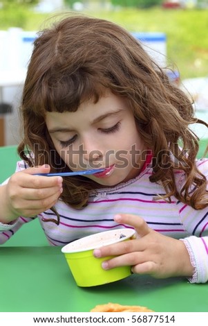 brunette little girl eating summer ice cream color spoon