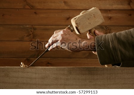 gouge wood chisel carpenter tool hammer in hand working wooden background