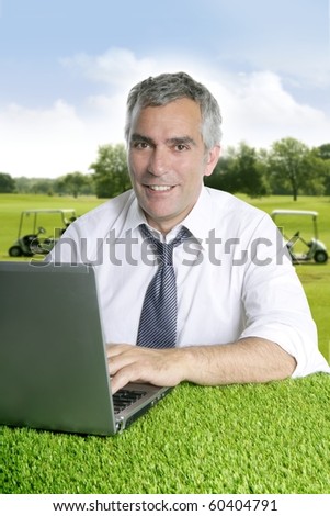 senior businessman golf course working computer green grass desk [Photo Illustration]