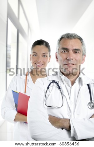 expertise gray hair doctor beautiful nurse in hospital white corridor [Photo Illustration]