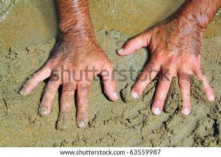 stock photo Hairy man hands on beach sand in sunny summer day