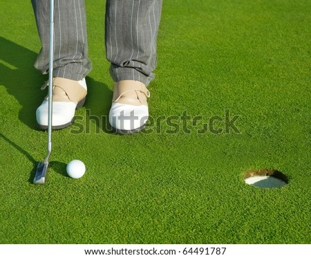 Golf green hole course man putting ball inside short putt