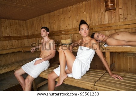 Sauna spa therapy beautiful young people group in warm wood room white towel