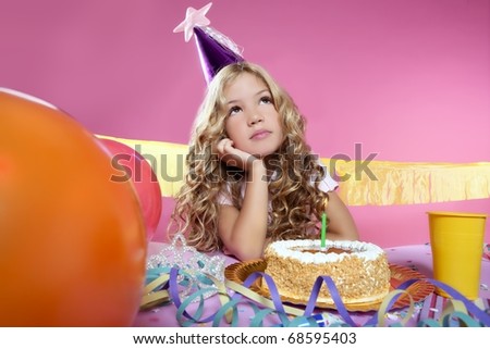 bored little blond girl in a birthday party with cake and candle on pink background
