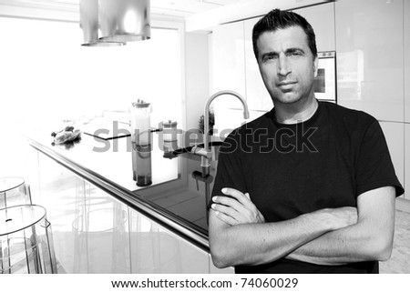 Medium age man in modern kitchen interior portrait crossed arms [Photo Illustration]