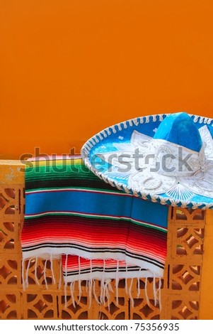 charro mariachi blue mexican hat serape poncho over orange tiles wall