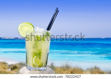 Cocktail mojito ice lemon straws in tropical beach balearic Islands