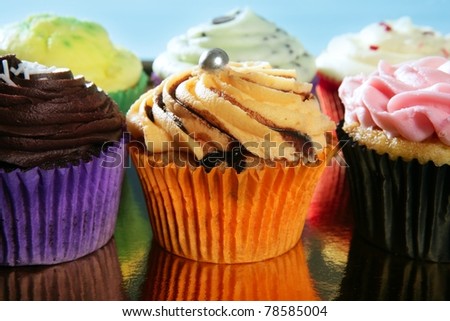 Cupcakes colorful cream muffin arrangement in golden mirror tray