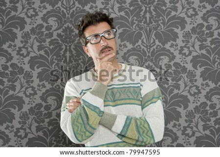 nerd  silly man with pensive expression over retro wallpaper background