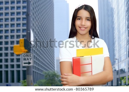 brunette teen  indian latin student holding school books in modern city buildings [Photo Illustration]