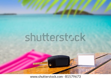 Car rental keys on wood table with blank paper in vacation tropical beach [Photo Illustration]
