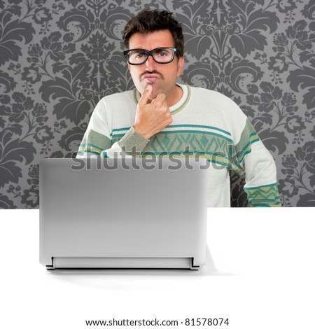 Nerd pensive man with glasses and silly expression in front a laptop computer looking for solution [Photo Illustration]