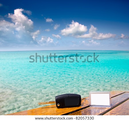 Car rental keys on wood table with blank paper in vacation Caribbean tropical beach [Photo Illustration]