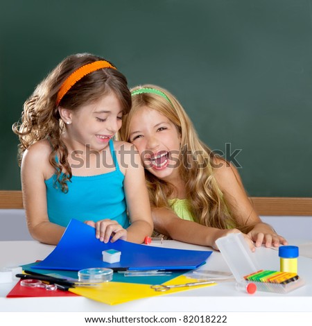 happy laughing student girls group at school classroom desk