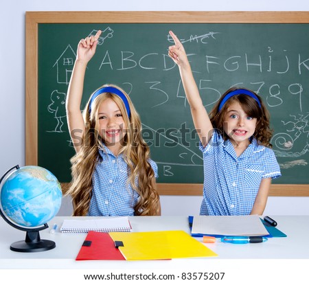 smart students in classroom raising hand with blackboard