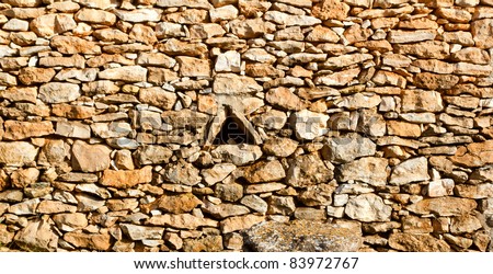 aged masonry stone wall triangle window hole Mediterranean Spain architecture