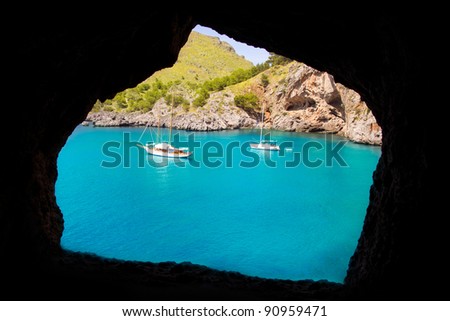 Escorca Sacalobra beach view from cave window with anchor boats in Mallorca