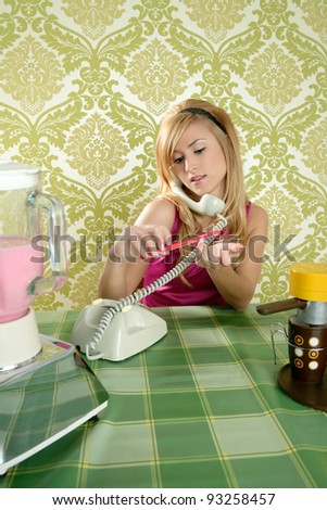 Housewife retro vintage talking phone in kitchen with nail file